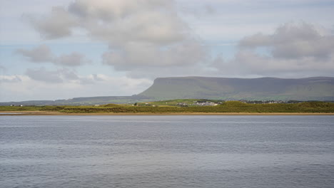 Time-Lapse-of-sea-coast-of-Ireland-with-hills-in-the-distance-and-moving-clouds-in-the-sky