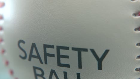 toma macro cinematográfica suave de una pelota de base blanca, primer plano en puntos rojos, pelota de seguridad, béisbol en un soporte brillante, iluminación de estudio profesional, panela de video 4k a la derecha