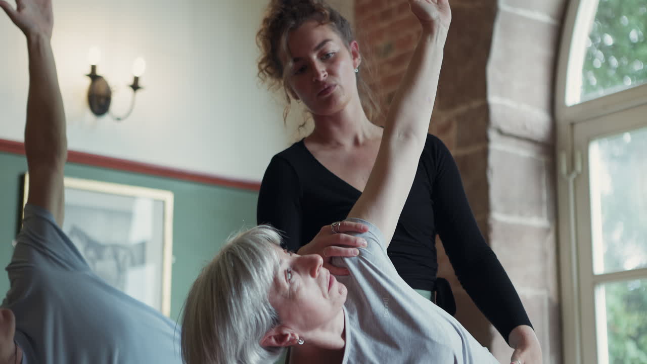 Yoga class with senior woman and instructor