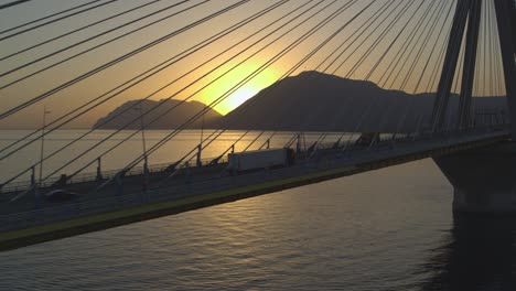 Antenne---Lastwagen,-Der-Bei-Sonnenuntergang-Auf-Der-Rio-Antirrio-Brücke-In-Griechenland-Vorbeifährt---Aufnahme-Auf-DJI-Inspire-2-X7-Raw