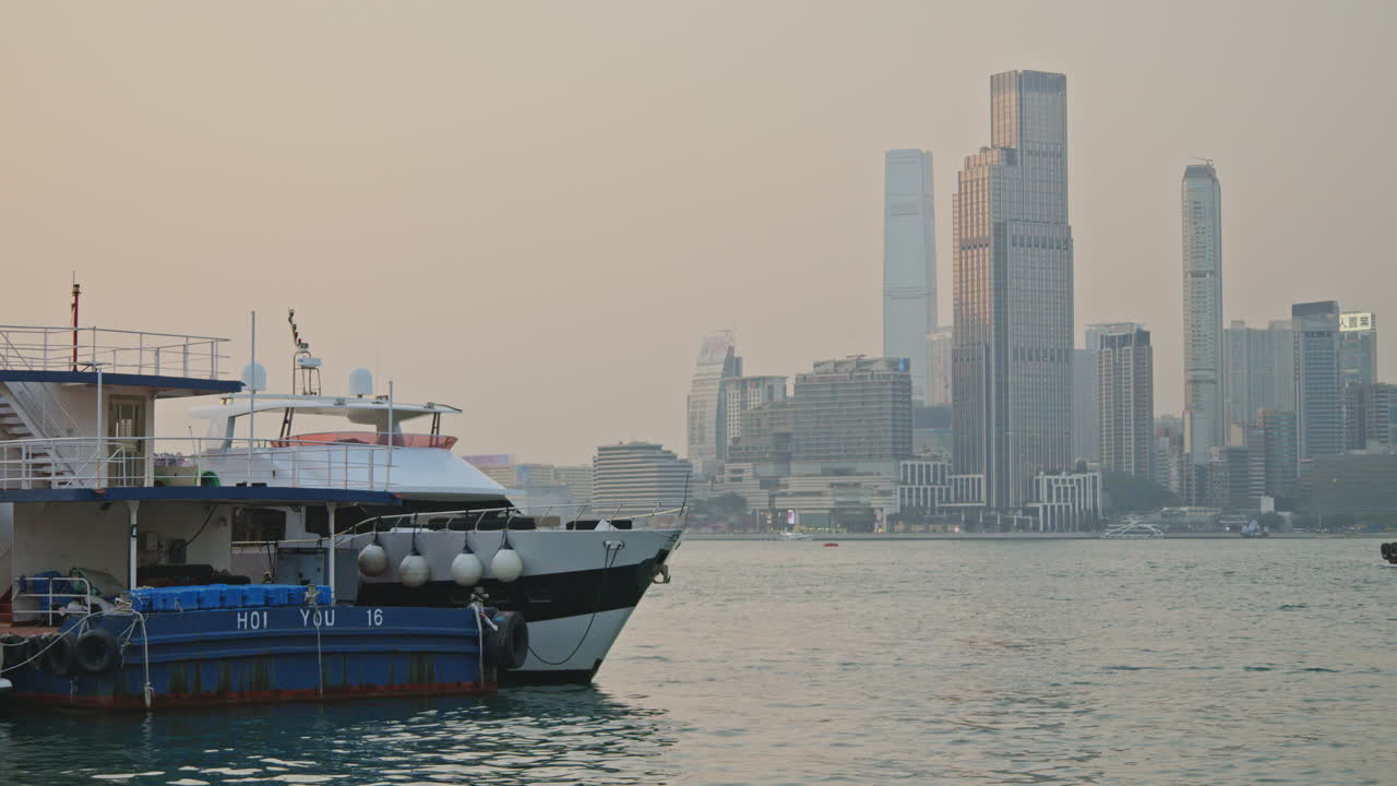 Boats Docked in a Calm Harbor with a City Skyline in the Background