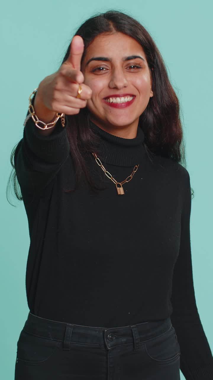 Indian woman smiling excitedly pointing to camera choosing lucky happy winner indicating hey you