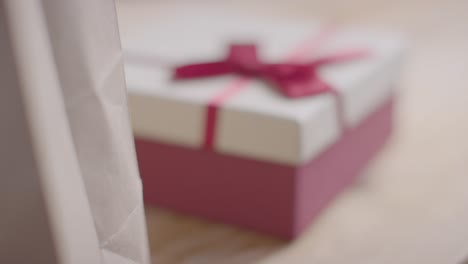 Close-Up-Of-Romantic-Valentines-Present-In-Gift-Wrapped-Box-On-Table-Coming-Into-Focus