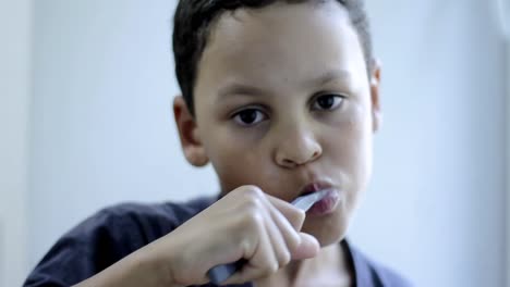 Niño-Cepillándose-Los-Dientes-Con-Un-Cepillo-De-Dientes-Con-Fondo-Gris-Almacen-De-Metraje-De-Video