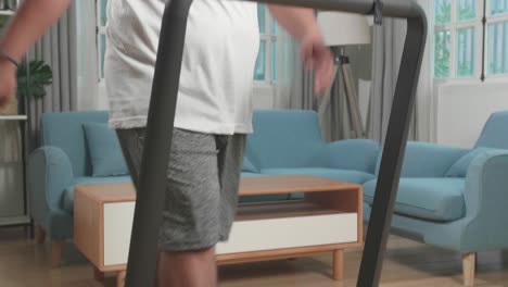 asian fat man training on walking treadmill at home