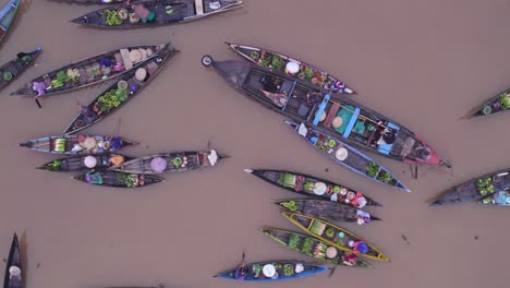 small boats floating in water with fresh produce at lok baintan market