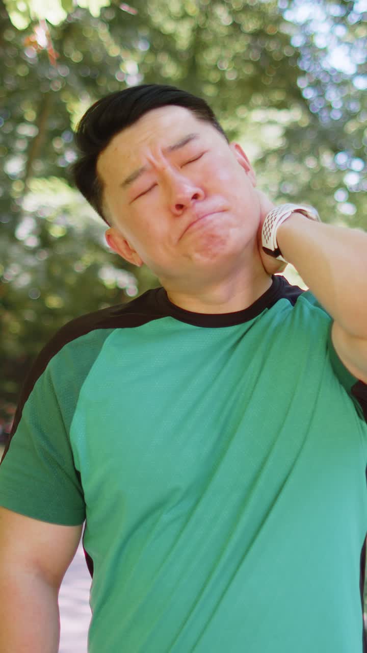 Asian man have shoulder neck joints pain sport injury concept after running in park outdoors