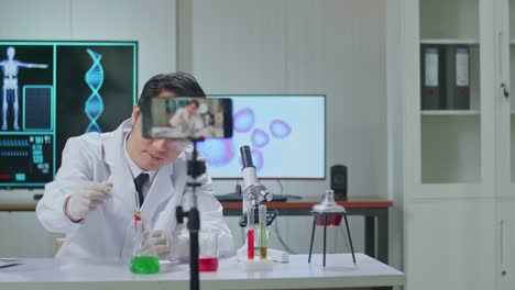 asian scientist man using smartphone recording video while researching in the laboratory