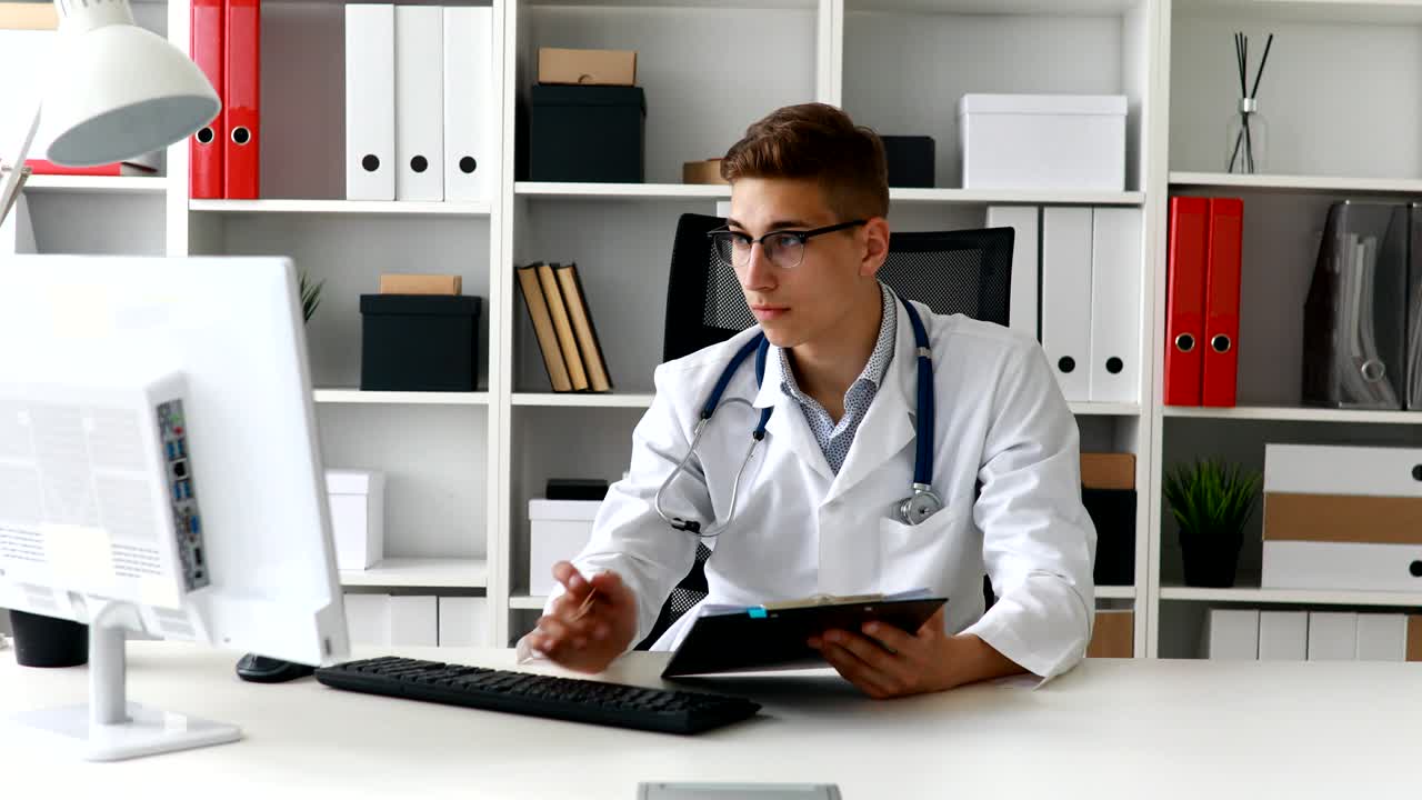 Jovem médico trabalhando no computador no local de trabalho