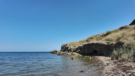 Waves-gently-lap-against-the-shore-as-the-sun-shines-brightly-over-the-stunning-Crimea-coastline,-revealing-the-natural-beauty-of-the-region