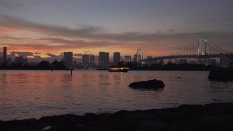 a beautiful sunset view of the rainbow bridge in odaiba, tokyo japan