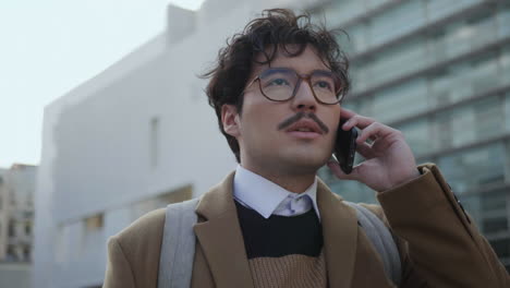 Business-man-having-phone-conversation-outdoors.-Employee-using-phone-on-street