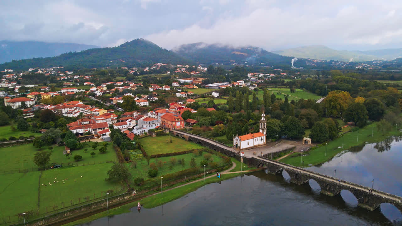impresionantes imágenes aéreas en 4k de un pueblo - ponte de lima en portugal y su punto de referencia icónico - puente romano de piedra que cruza el río lima