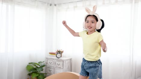 4k 50fps, a cute little girl wearing asian bunny ears, jumping on her favorite sofa, with a joyful expression on her face, in her bedroom.