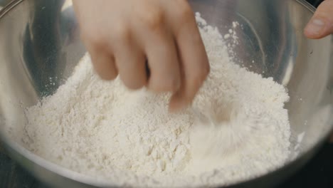 mixing spices with cooking flour inside deep metal bowl