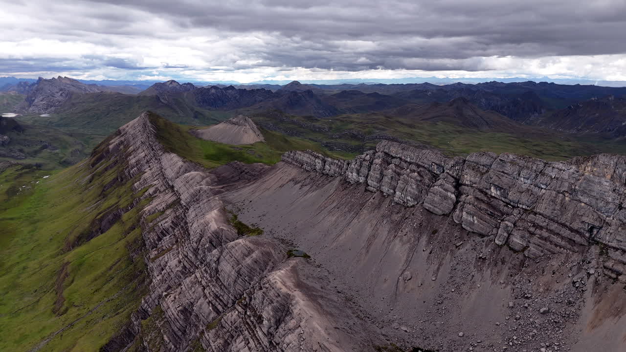 Vista aérea cinematográfica de los nevados Andes en Perú, con glaciares, acantilados rocosos y un lago alpino azul oculto bajo nubes brumosas, paisaje espectacular y destino turístico natural