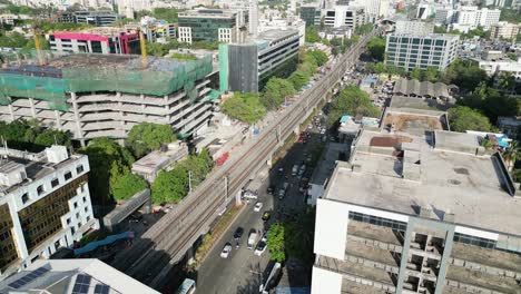 Im-Bau-Befindliches-Gebäude-Neben-Der-U-Bahn-Station-Marol-Statisch-Und-Der-Zug-Fährt-In-Den-Bahnhof,-Draufsicht