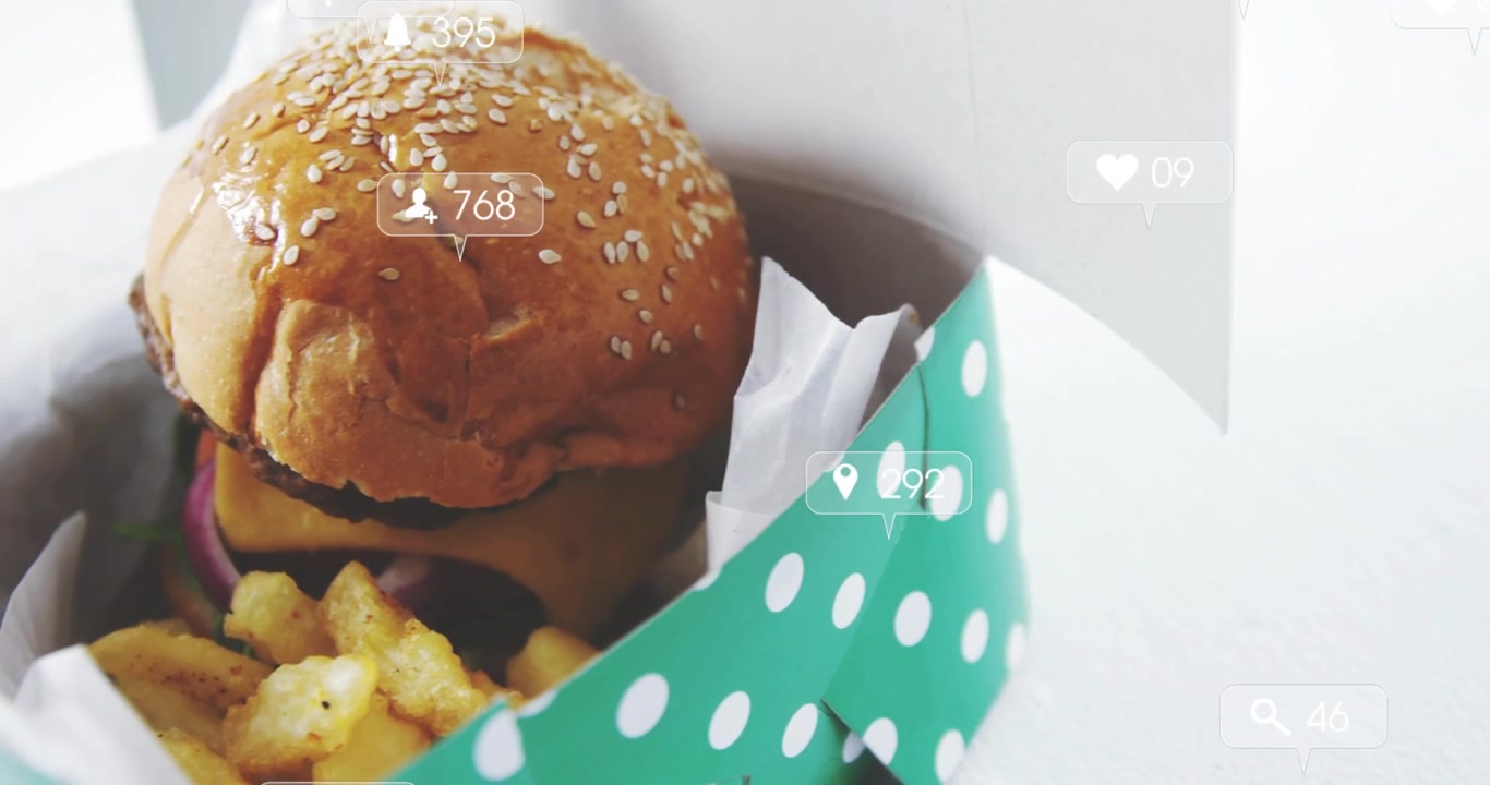Green polka-dot box entering left, revealing burger and fries, social-media icons promoting reach