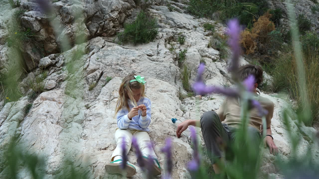 Kids resting on a rocky mountain with lavender