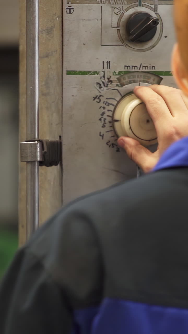 Factory Worker Adjusting Machine Settings