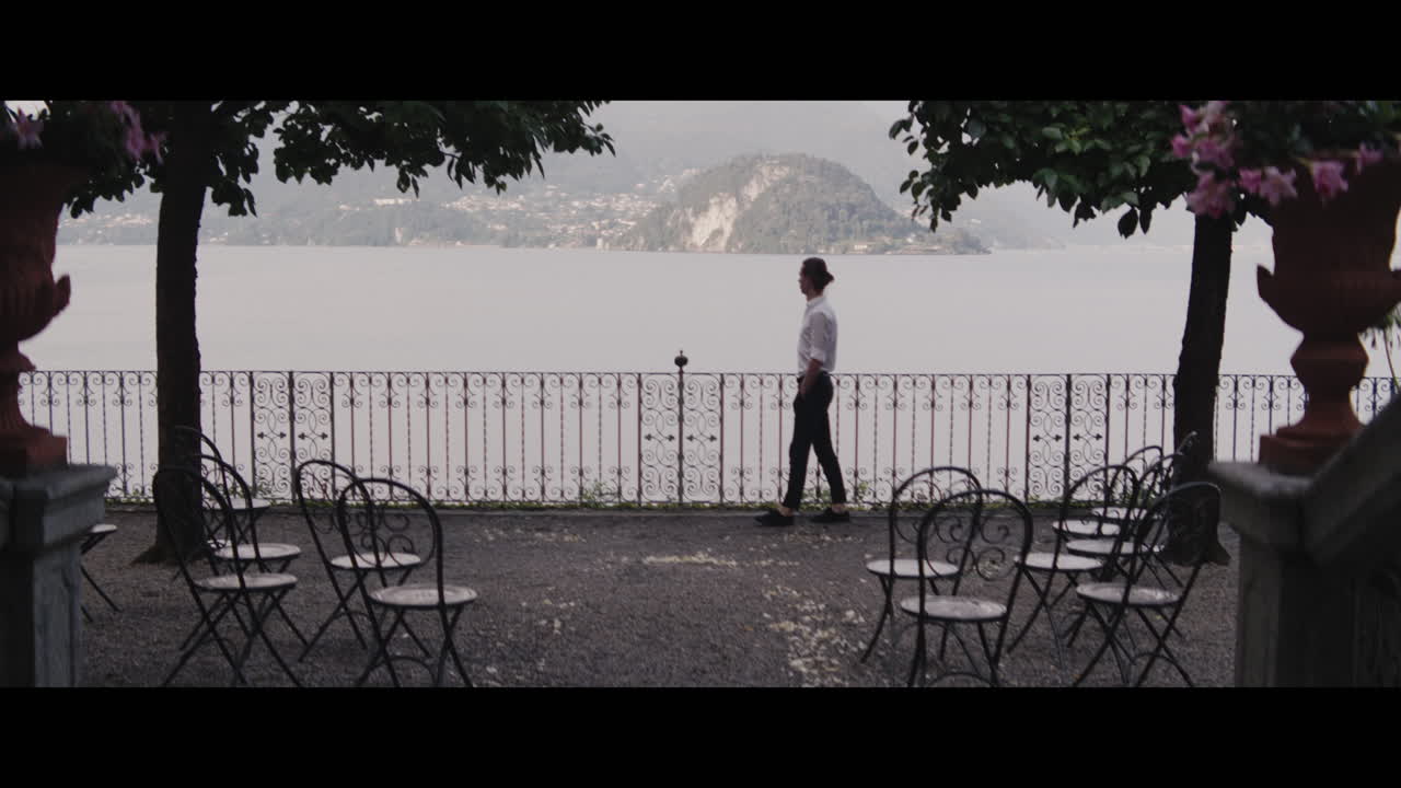 Man Walking on Balcony with Lake View