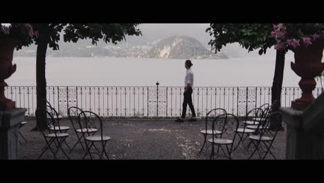 man walking on balcony with lake view