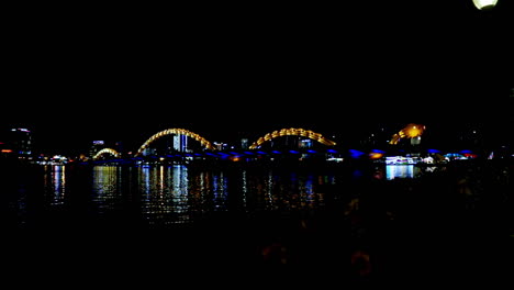 standing and looking at the bridge at night in da nang