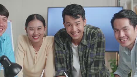 close up of asian engineers group smiling to camera while working about the wind turbine at the office