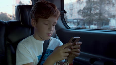 boy spending time with mobile during car ride