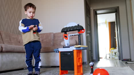 kid with toy workbench indoors. a young child engaged with a colorful toy workbench, exploring tools in a cozy living room setting during daytime