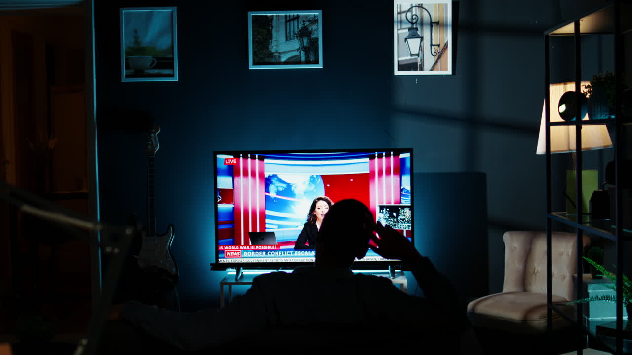 밤 에 텔레비전 에서 뉴스 를 보고 있는 편안 한 사람