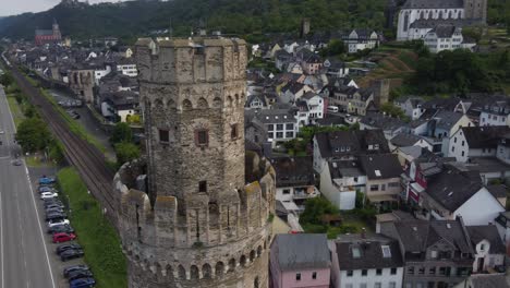 Freight-Train-transporting-Cargo-Containers-passing-Medieval-Ox-Tower-of-Oberwesel-Town,-Germany