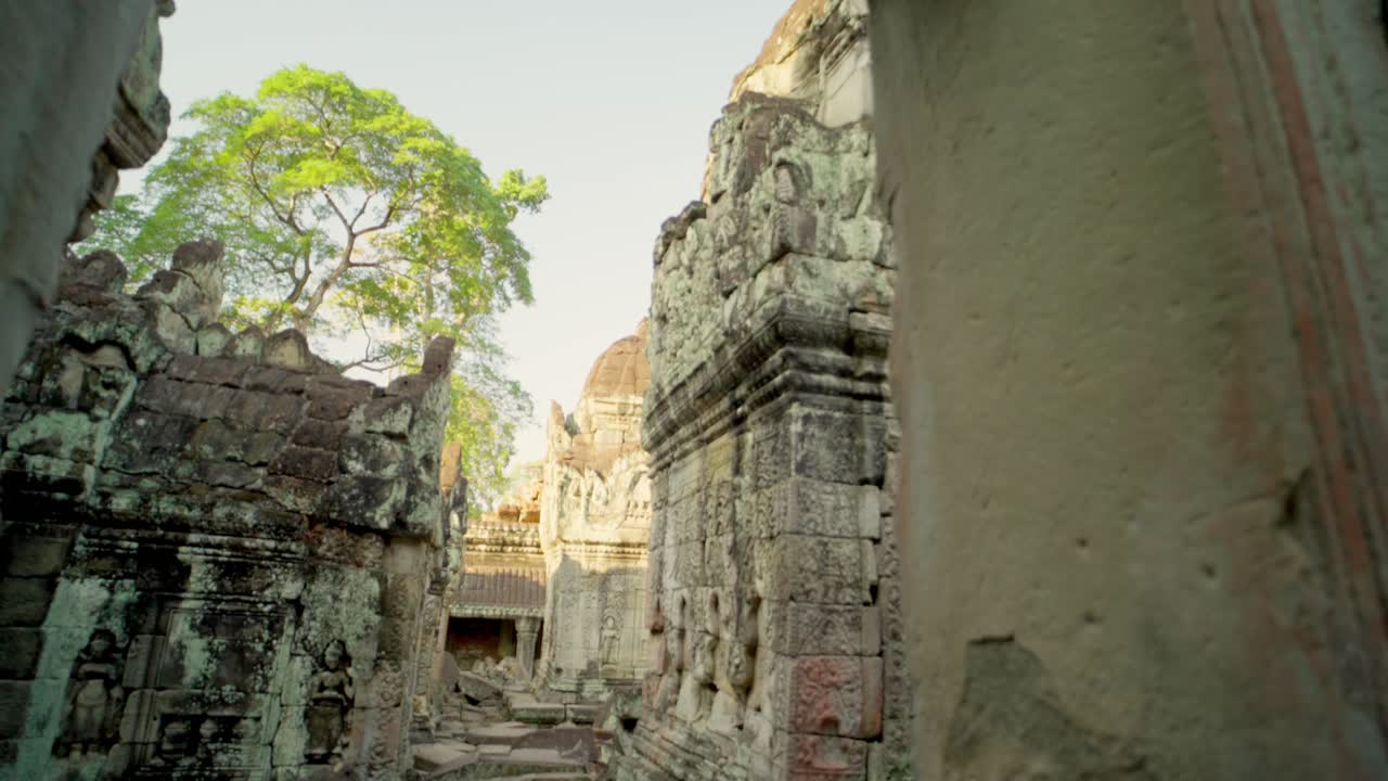 Sacred Khmer towers emerge from shattered stone ruins deep in jungle corridor
