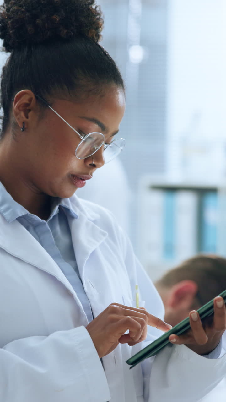 Scienziata concentrata che usa un tablet digitale in laboratorio