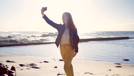 woman taking selfie with mobile phone at beach 4k