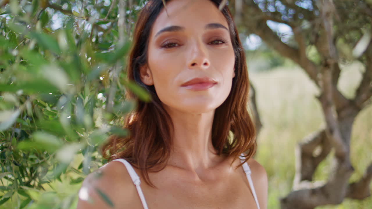 Chica romántica contemplando la naturaleza relajándose en el parque sintiéndose tranquila de cerca