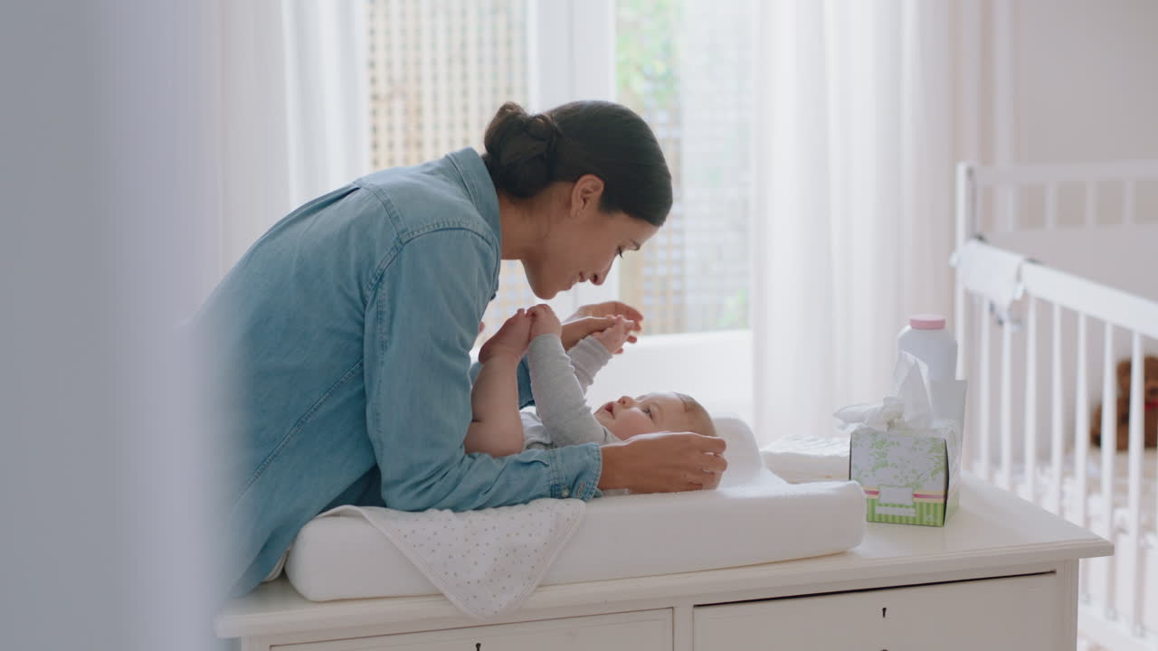 행복한 엄마가 부드럽게 키스하는 아기 즐기는 사랑하는 엄마가 집에서 변기 테이블에서 유아를 놀이로 돌보는 그녀의 신생아와 연결을 공유하는 건강한 보육
