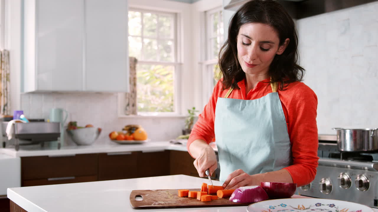 mujer cortando zanahorias en la cocina para la comida judía de la pascua