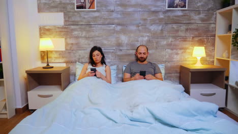 zoom in shot of couple laying in comfortable bed