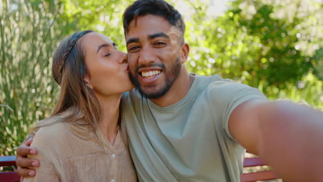 selfie, love and interracial couple in park kiss