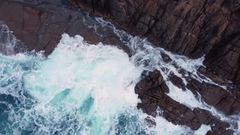 ocean waves hitting rocky cliffs in arteixo, spain - aerial orbit