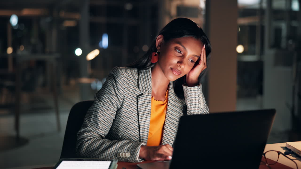 Tired Young Businesswoman Working Late on Laptop in Dark Office