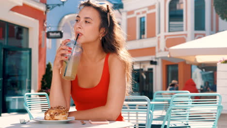 woman enjoying a drink and dessert in a cafe