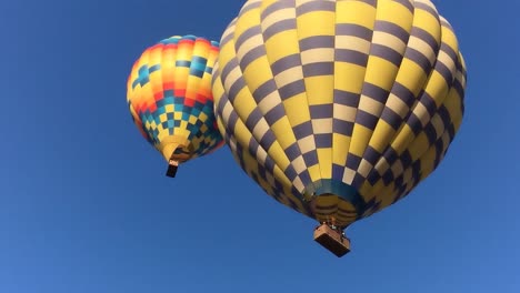 ms on hot air balloons as they descend, flame from the boiler shot up from basket, blue sky in background