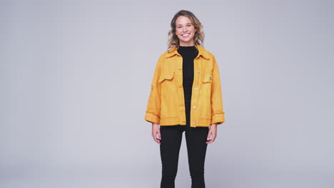 Studio-Shot-Of-Young-Woman-Walking-Into-And-Out-Of-Frame-Against-White-Background-In-Slow-Motion