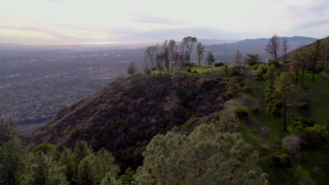 una foto de un dron de un claro en un mirador en la cima de una montaña a la hora dorada