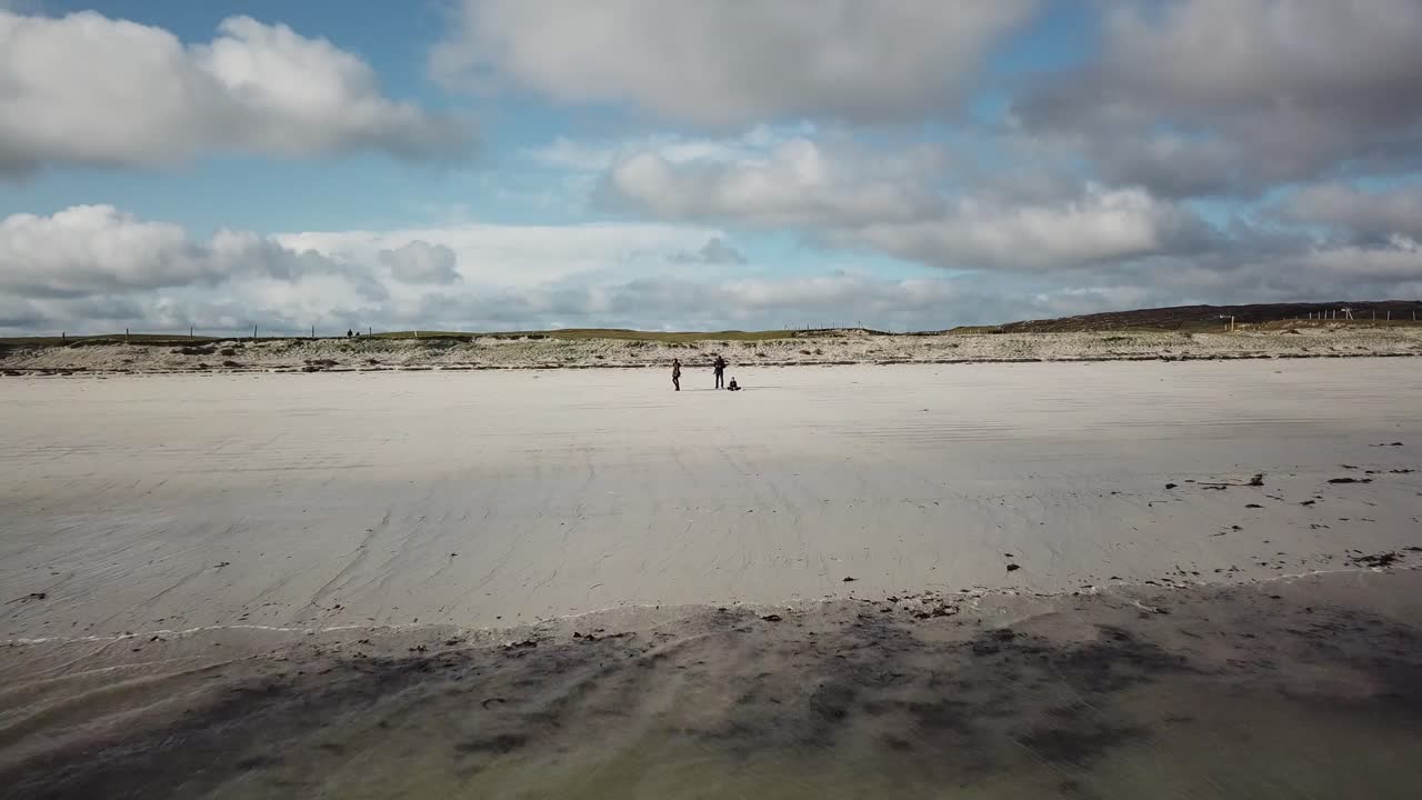 아일랜드 코네마라의 모래사장에서 바다를 드러내는 세 사람의 공중 전망