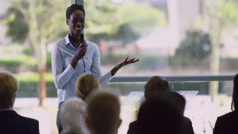 female speaker speaks in a business seminar at modern office 4k