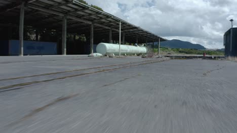 puddle of water on concrete floor at abandoned factory flying towards tank