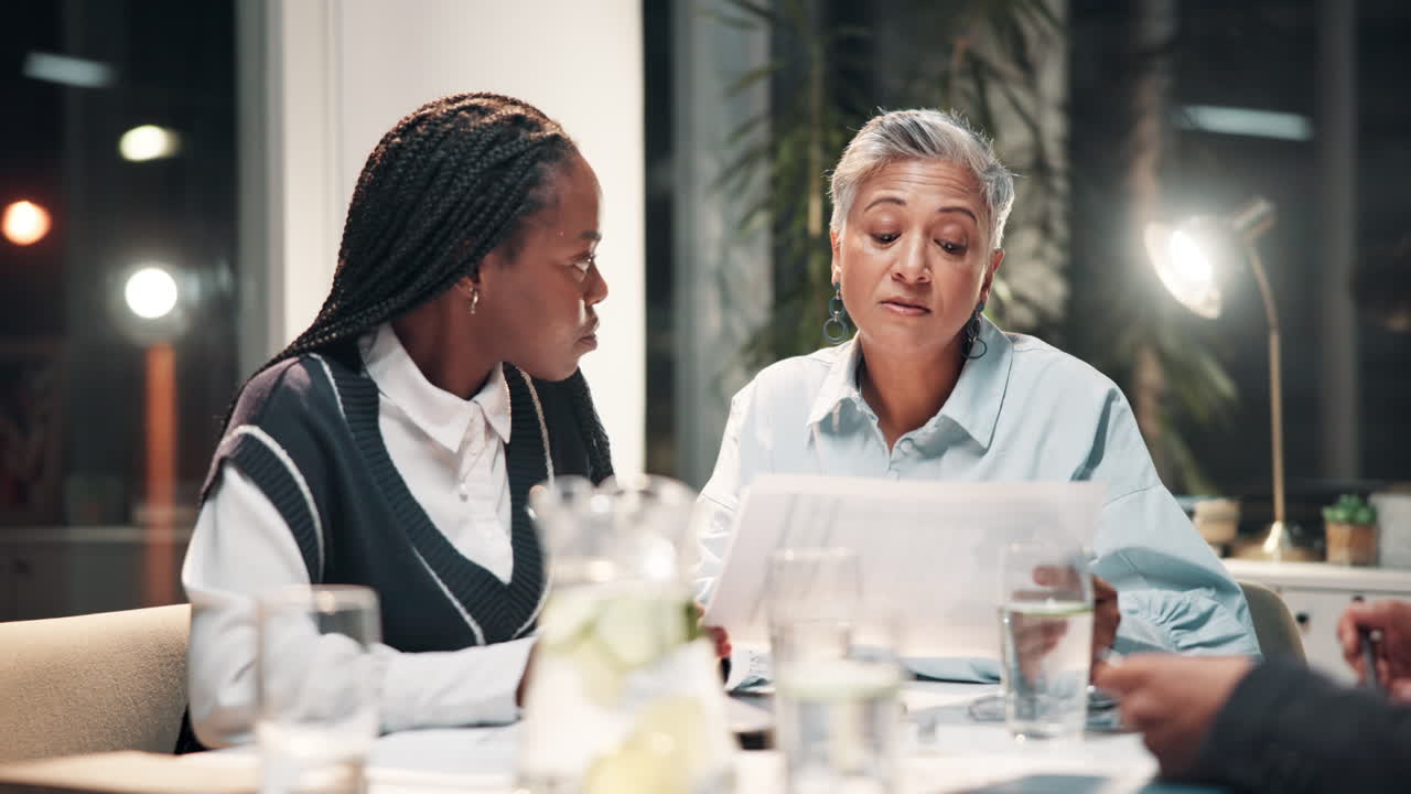 dos mujeres de negocios discutiendo gráficos durante una reunión